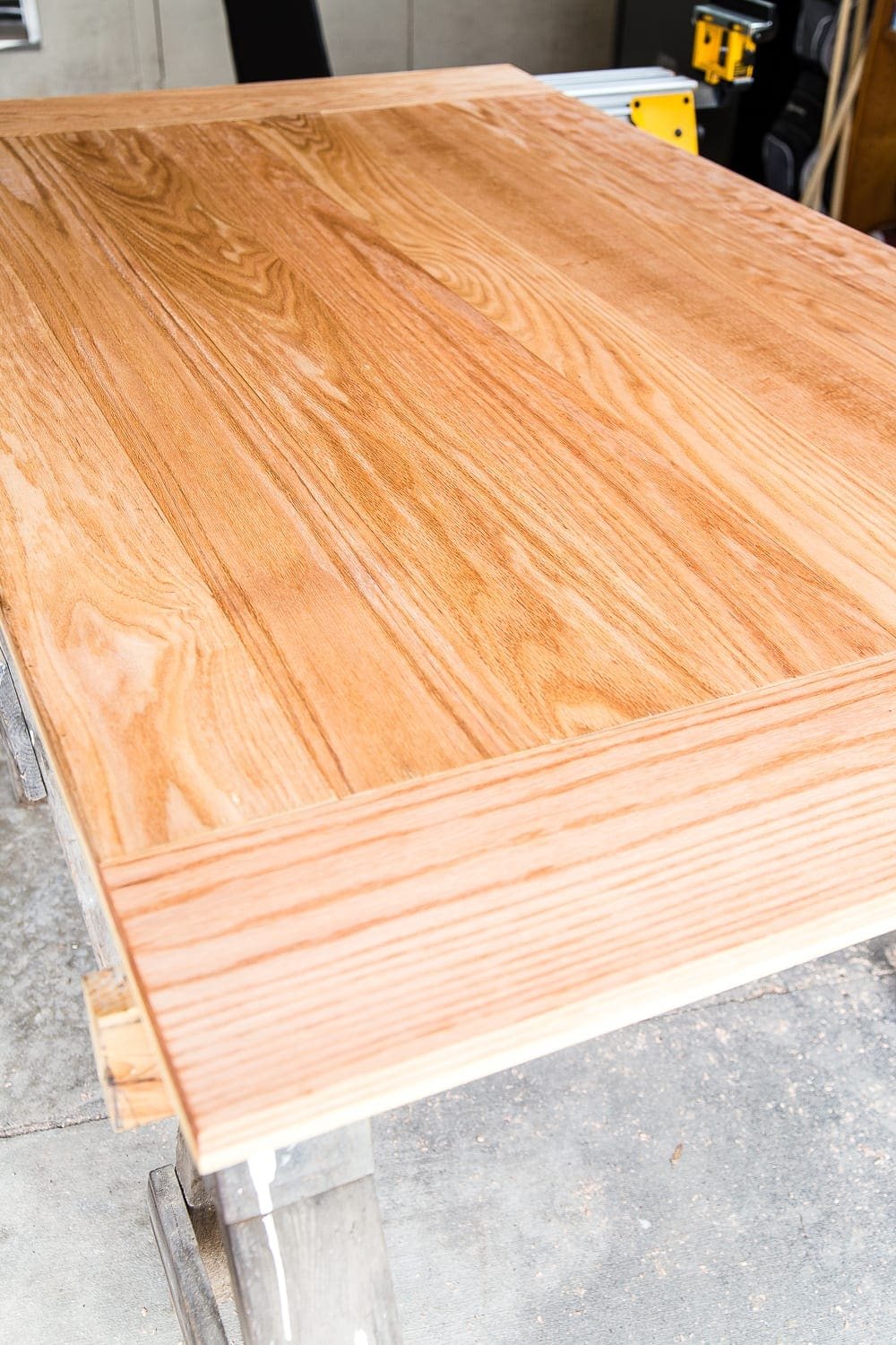 A tutorial for how to build a retrofitted table top to fit over any existing table using Minwax Dark Walnut stain. #build #furniturebuilding #tabletop #diningtable #diytable #farmhousetable #diyfurniture #woodworking #furnituremakeover #tablemakeover #minwax #woodstain #walnut
