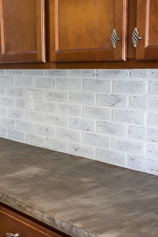 whitewashed faux brick backsplash with concrete countertop