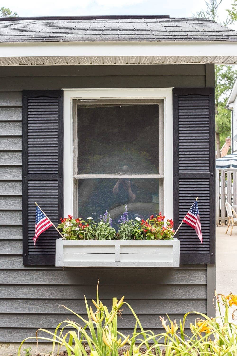 DIY window box using scrap wood with red, white, and blue patriotic flowers for July 4th