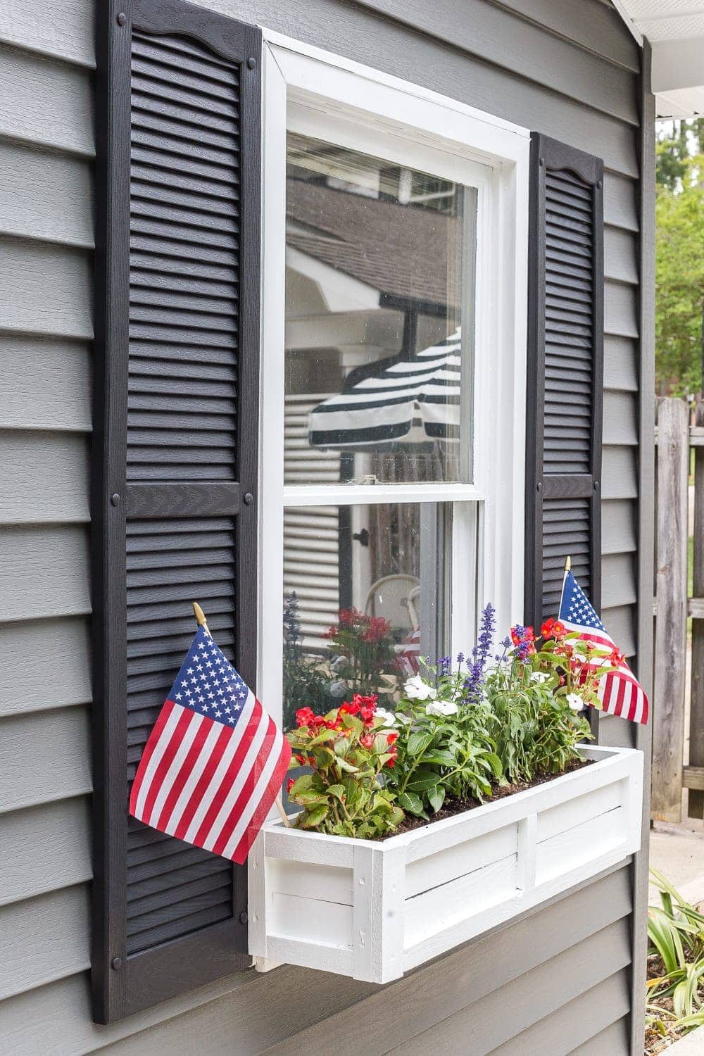 DIY window box using scrap wood with red, white, and blue patriotic flowers for July 4th