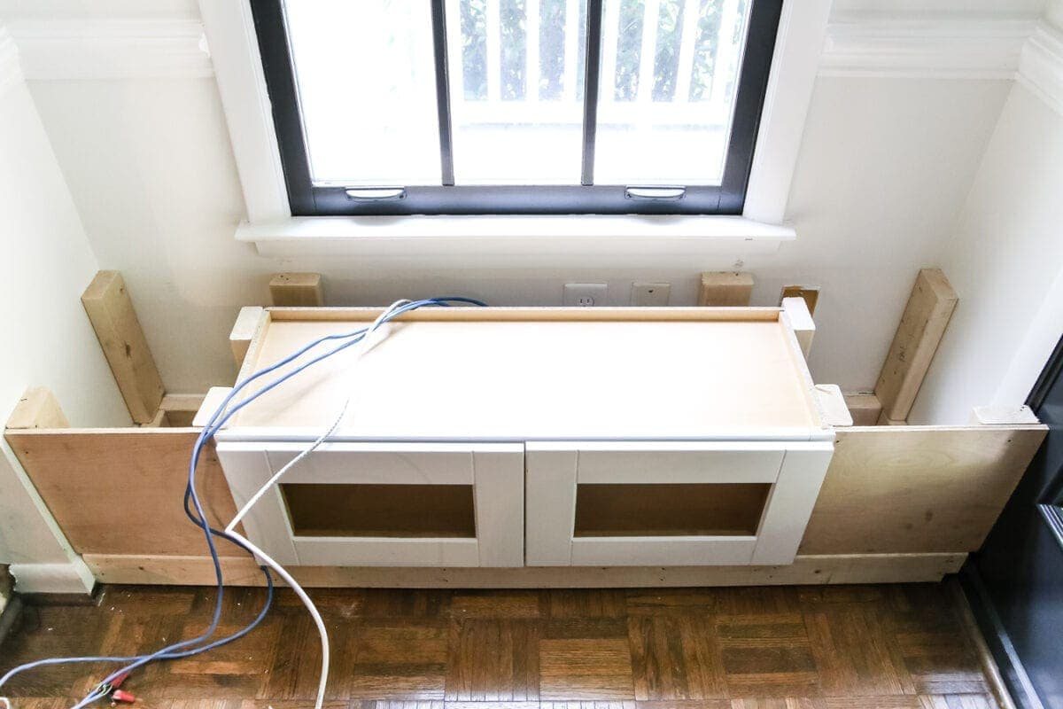 DIY Window Seat from a Kitchen Cabinet | unigumushane.com - A simplified tutorial for how to build a DIY window seat using a prefabbed kitchen cabinet to house electronics and hide cords.