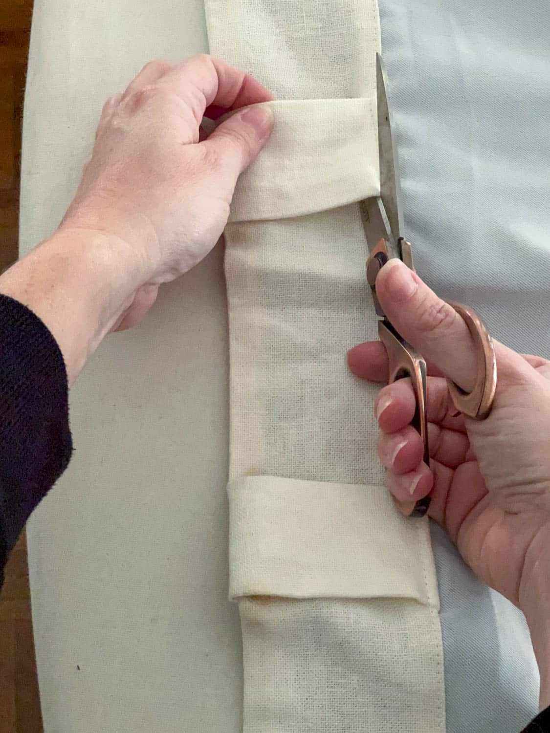 cutting back tabs of curtain with scissors