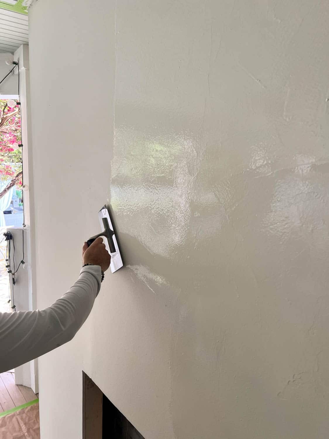 applying Romabio Venetian Glaze plaster paint with a trowel on a DIY plaster fireplace