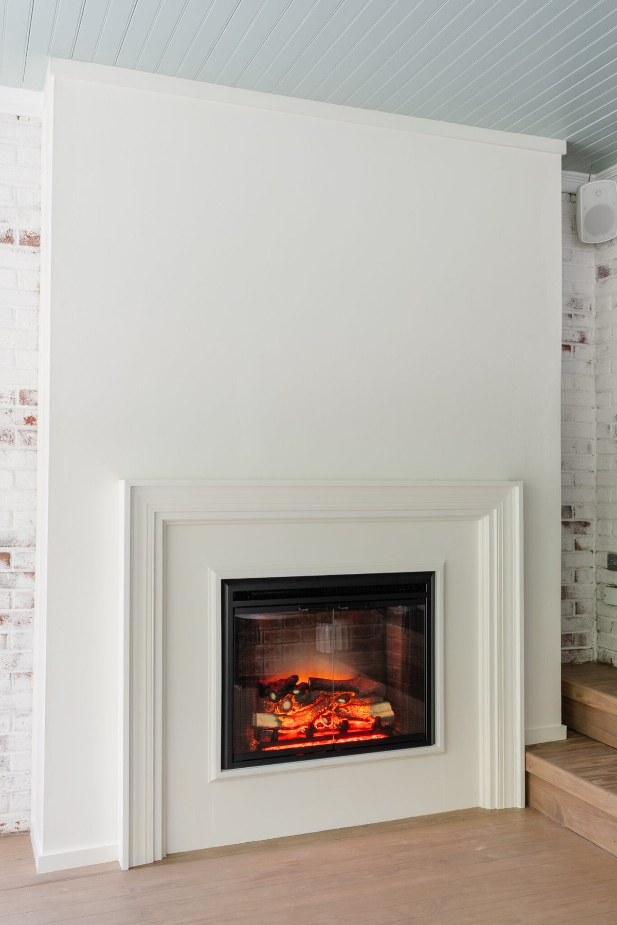 finished plaster fireplace with electric insert and limewashed brick