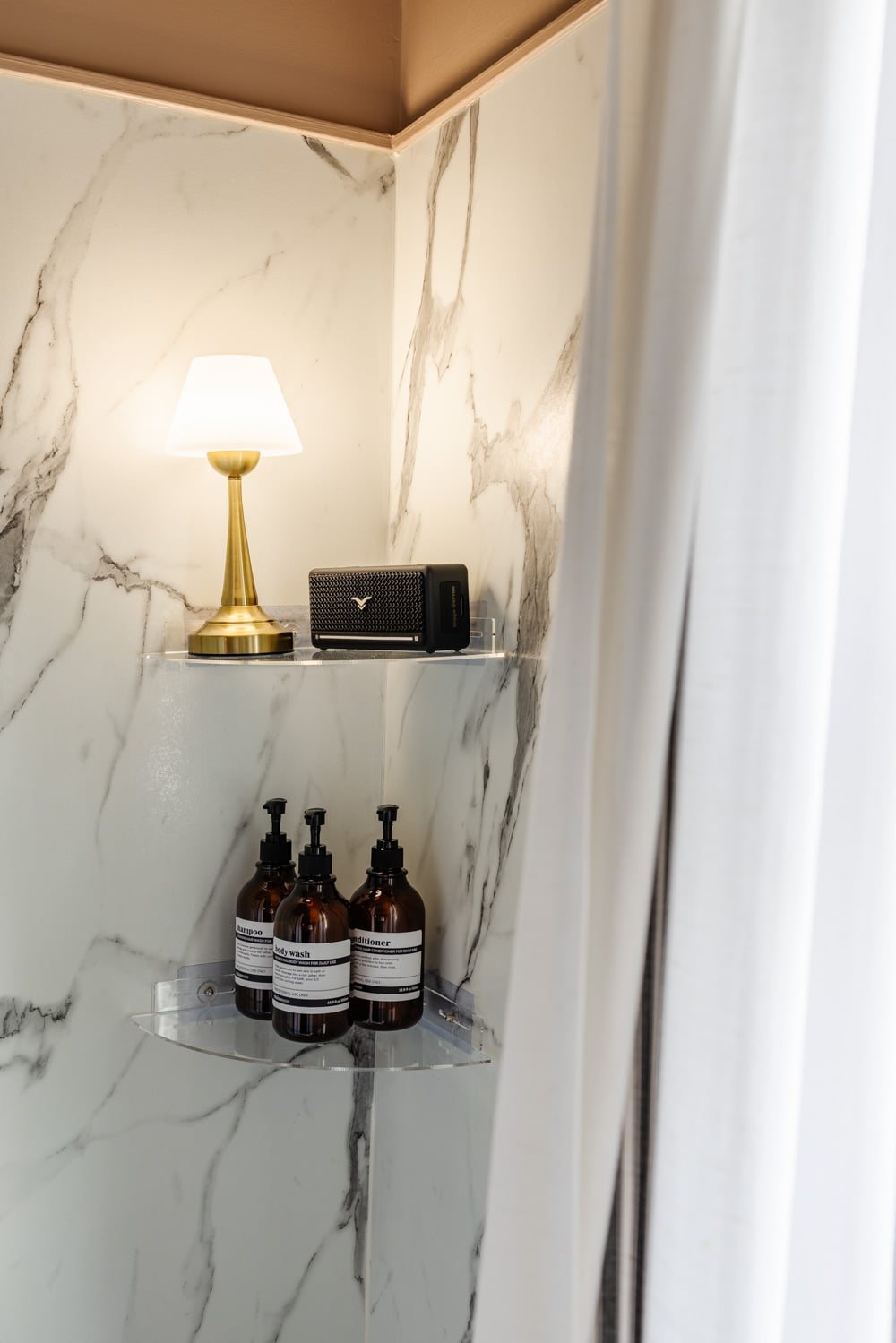 waterproof lamp on shower shelf with bluetooth speaker for a cozy bathroom