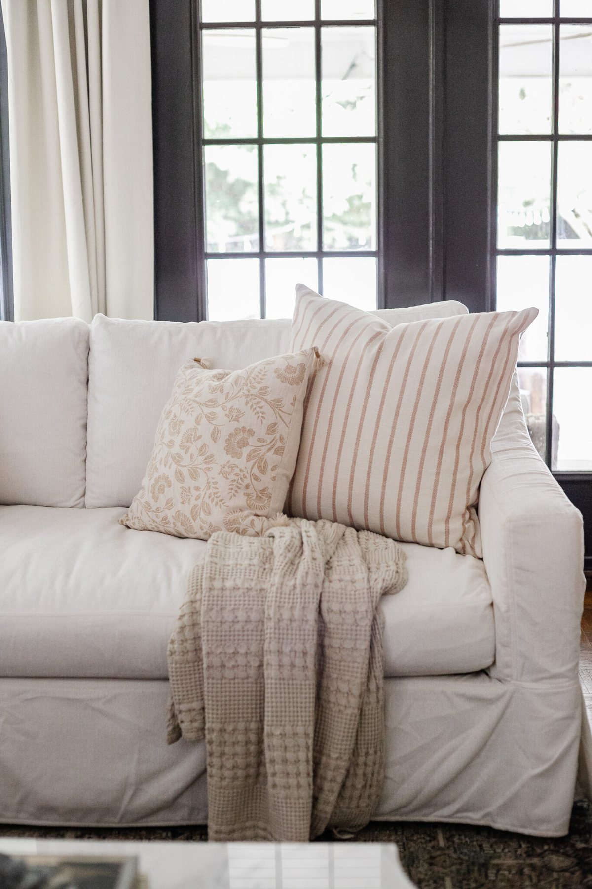 neutral fall pillows on a white couch in a living room decorated for fall