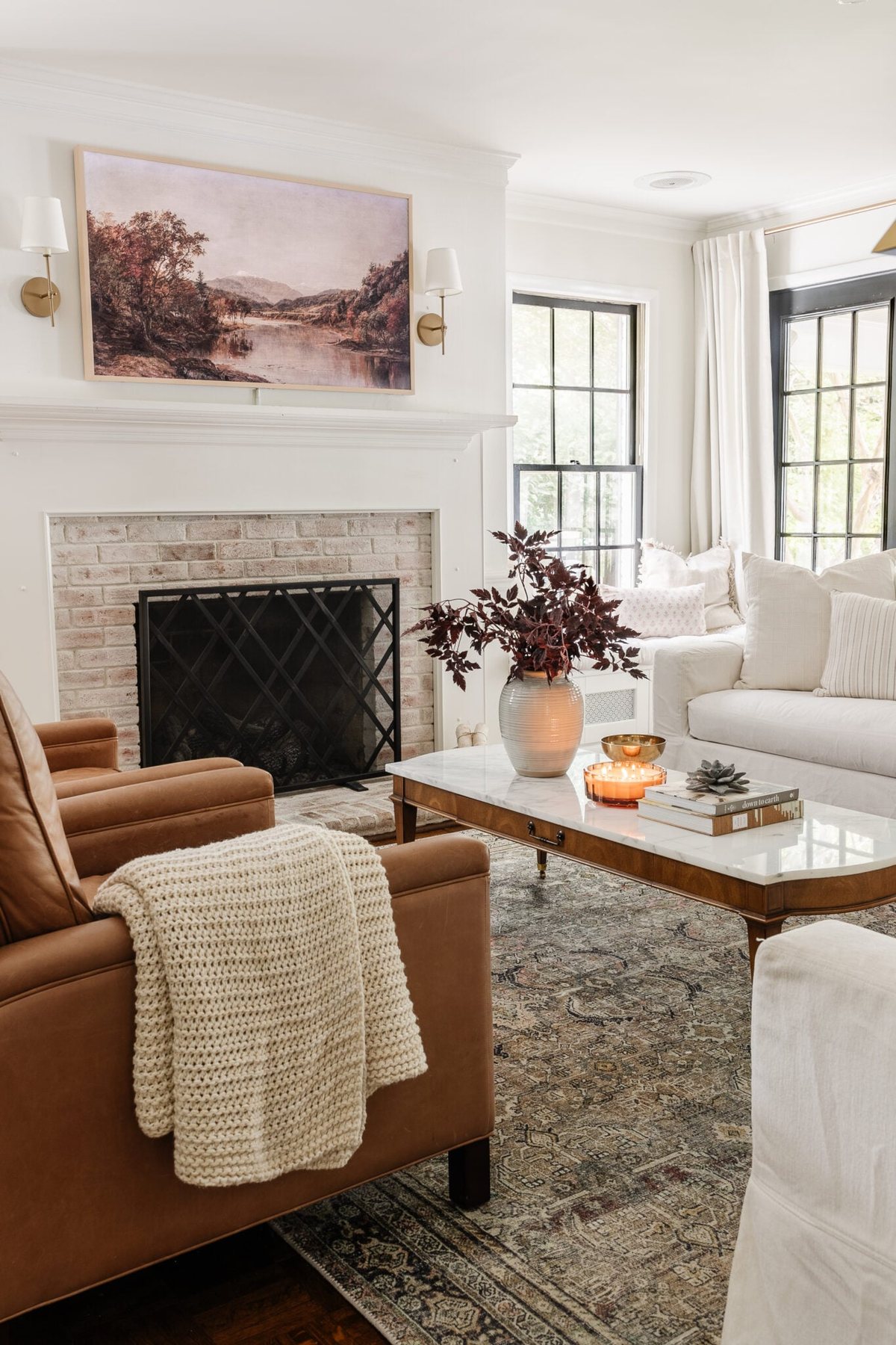 fall living room decor with fall TV art and a vase of leafy stems