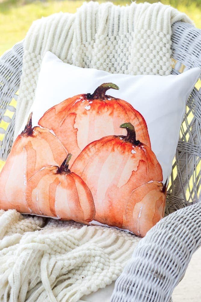 fall pillow with pumpkins on a porch