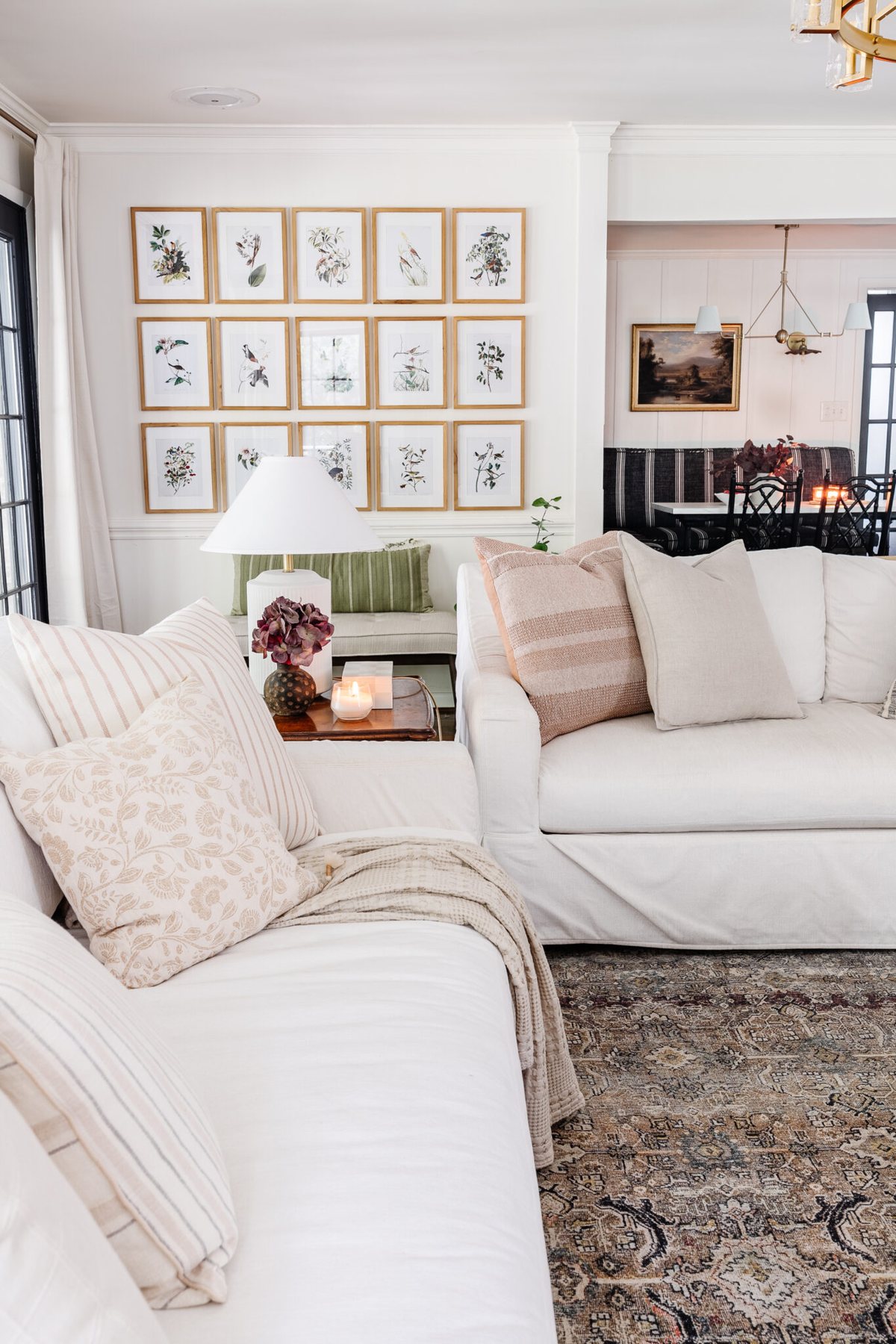 fall decorating ideas for living room with white sofas, lamps, and picture frame gallery wall