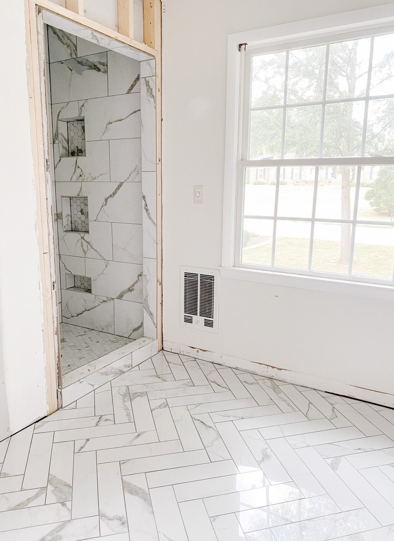 faux marble herringbone tile floor and faux marble tile shower with hexagon