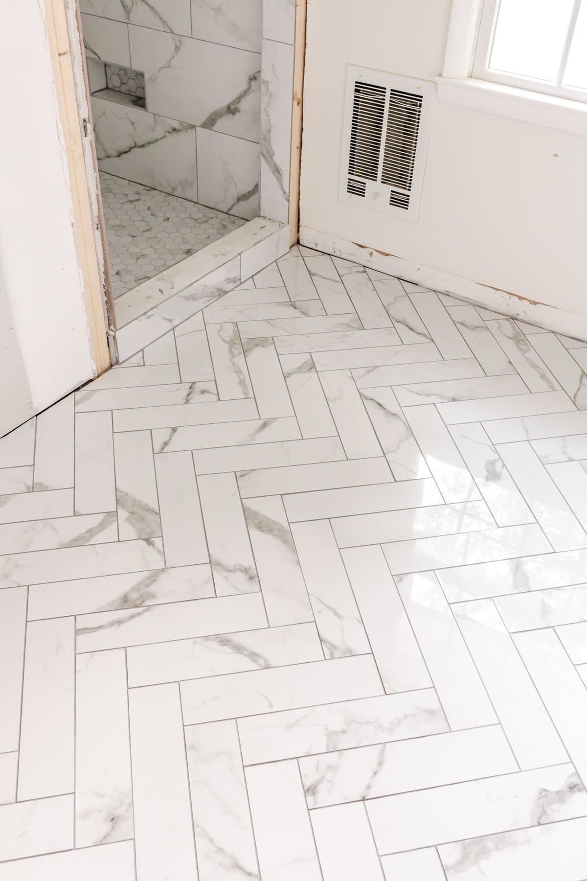 faux marble herringbone tile floor and faux marble tile shower with hexagon