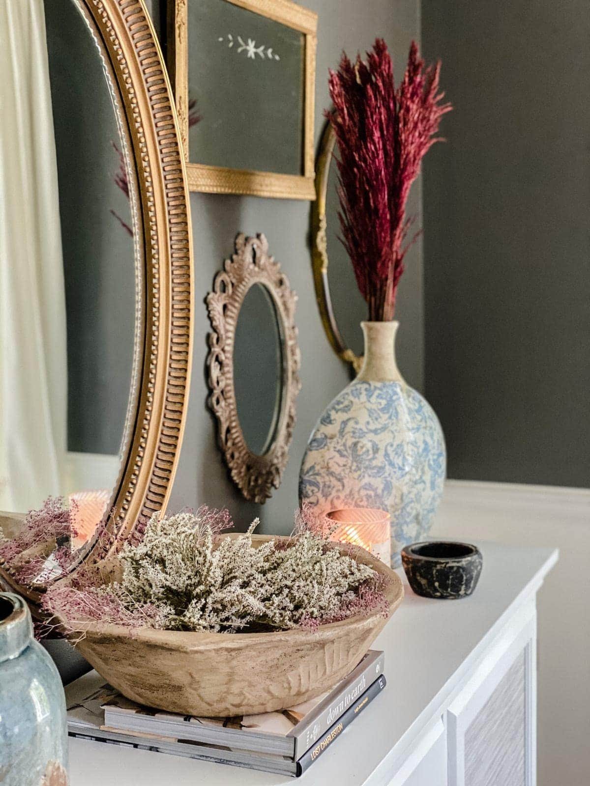 preserved flowers in a bowl on a buffet for fall dining room decor