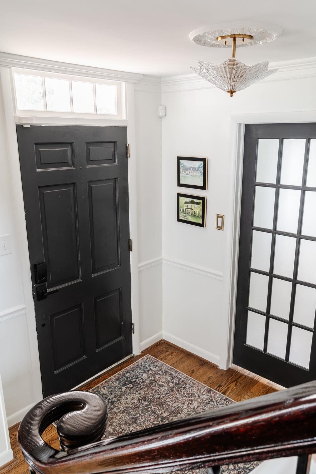 neutral foyer with black front door and french doors