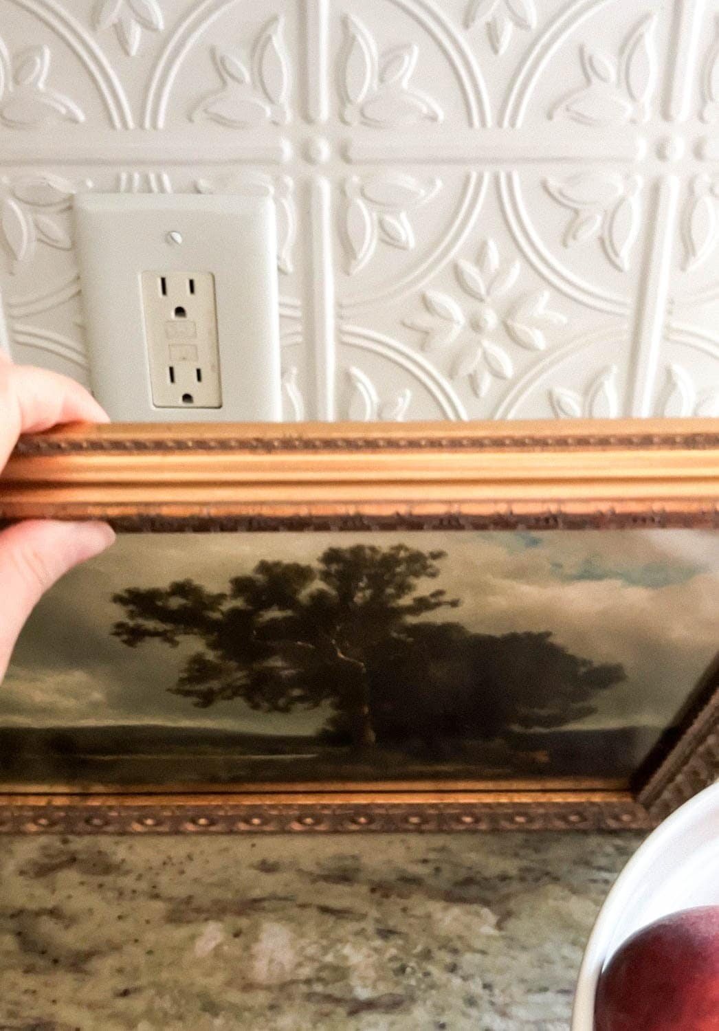 hiding a kitchen backsplash outlet with framed art
