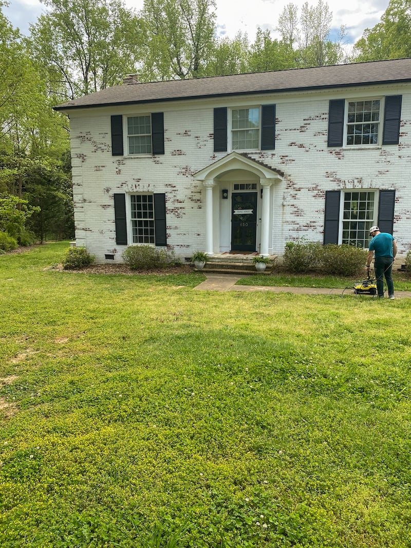 limewashed brick house before lawn makeover