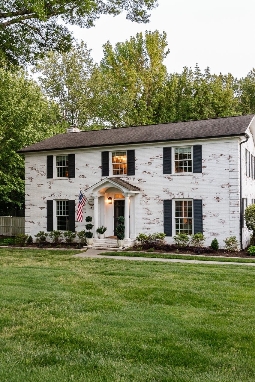white brick house with green grass in front