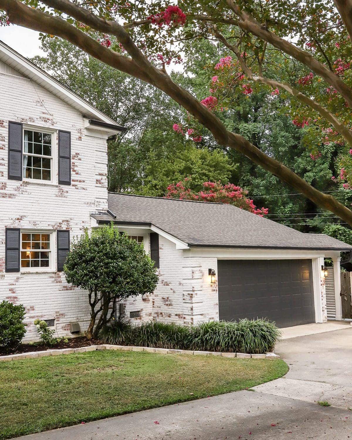 garage curb appeal with copper lanterns, star jasmine, and outdoor trash can hiding panels