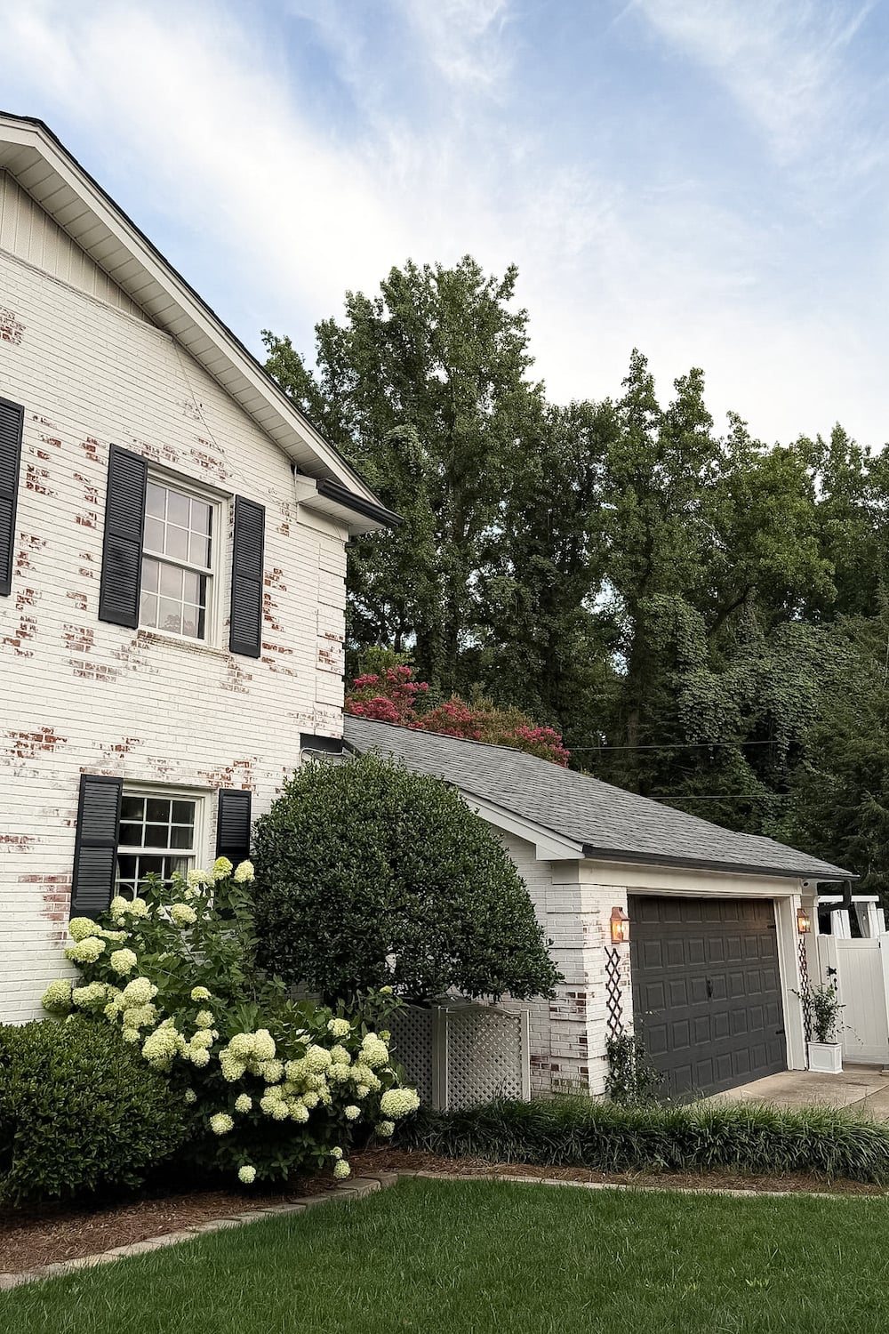 garage curb appeal with copper lanterns, star jasmine, and outdoor trash can hiding panels