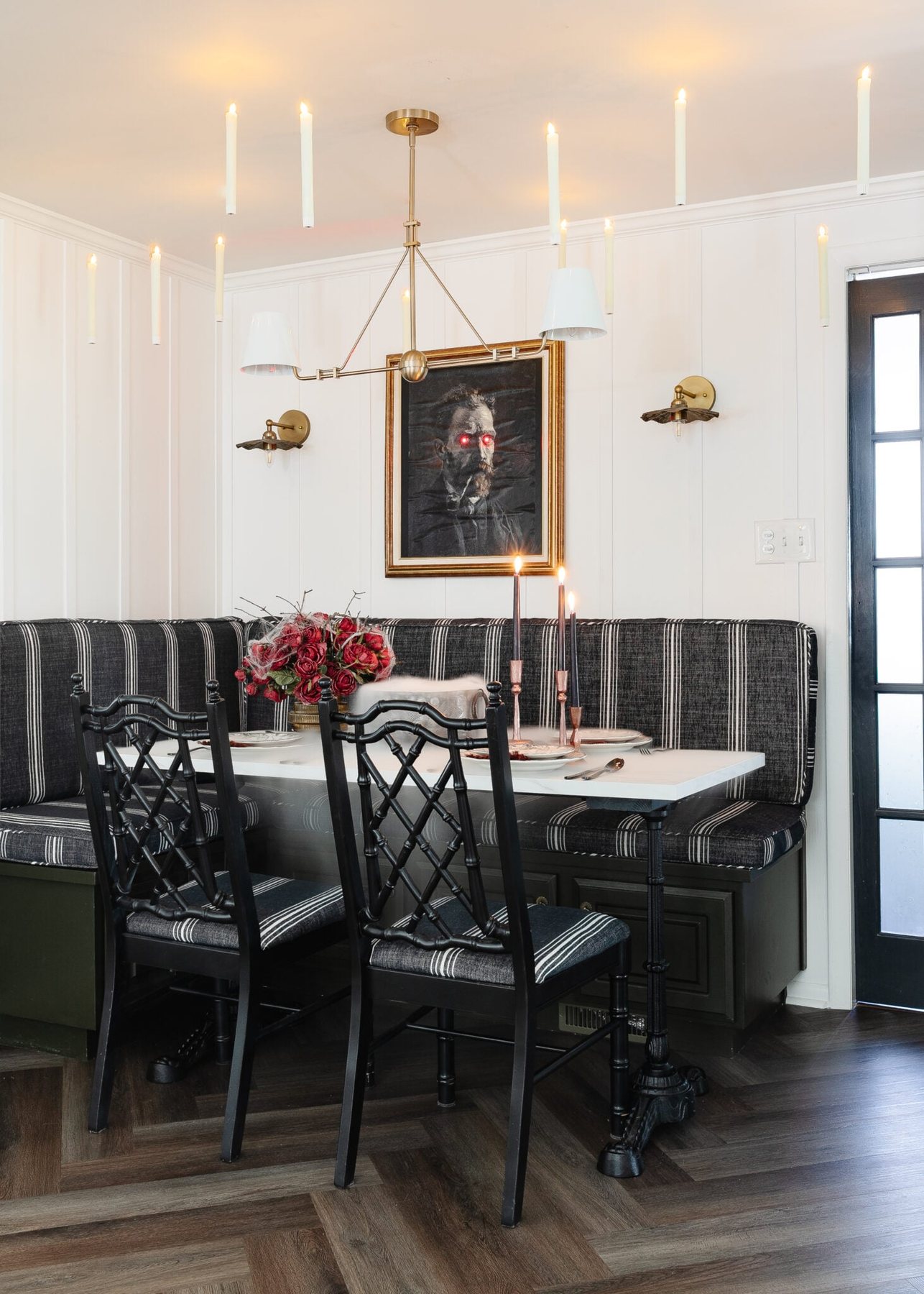 Halloween table decor ideas for a murder mystery dinner party with Halloween art portrait, floating candles, and dinnerware