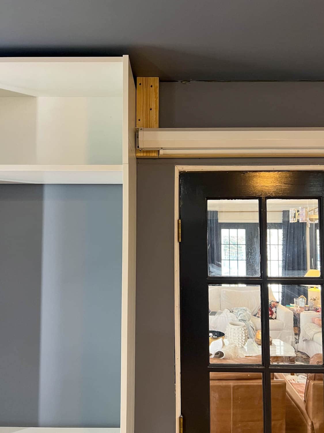 hanging projector screen on wall with 2x4s