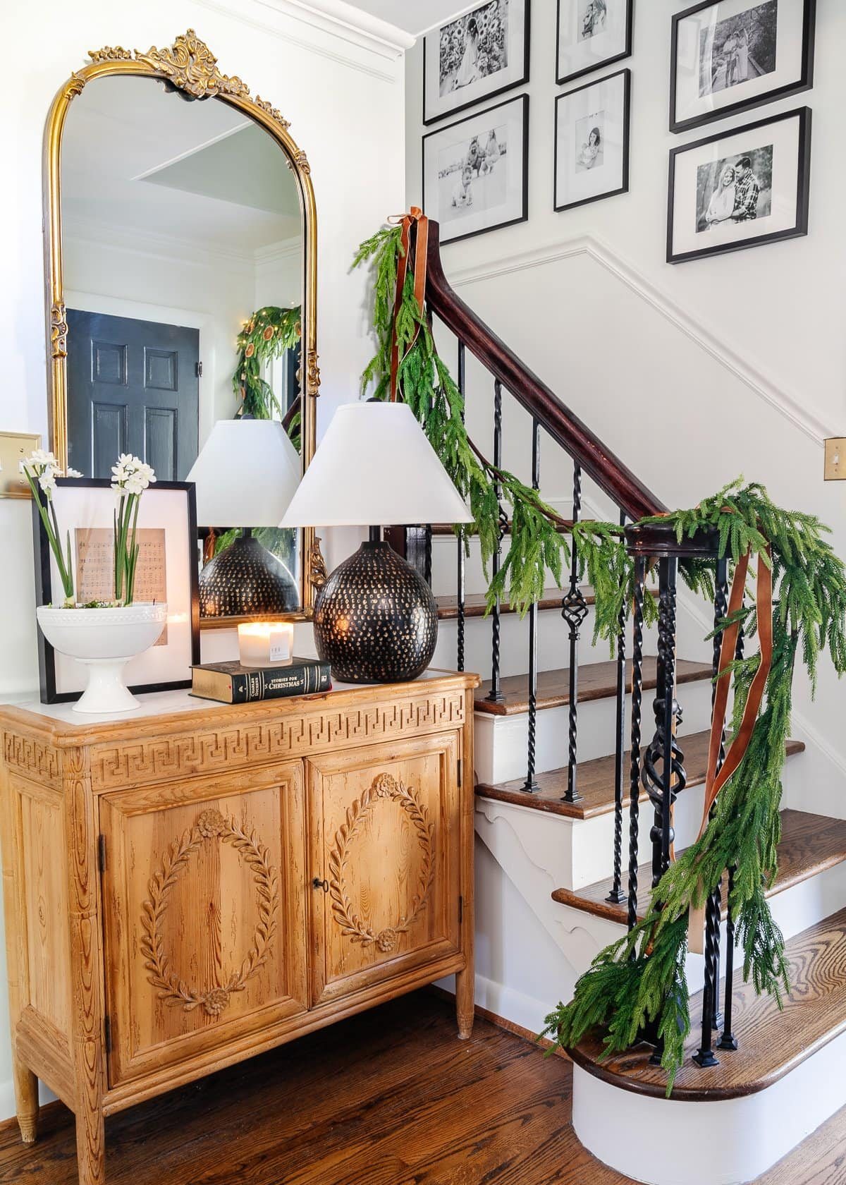 Christmas foyer decor ideas with garland on stairs and copper ribbon