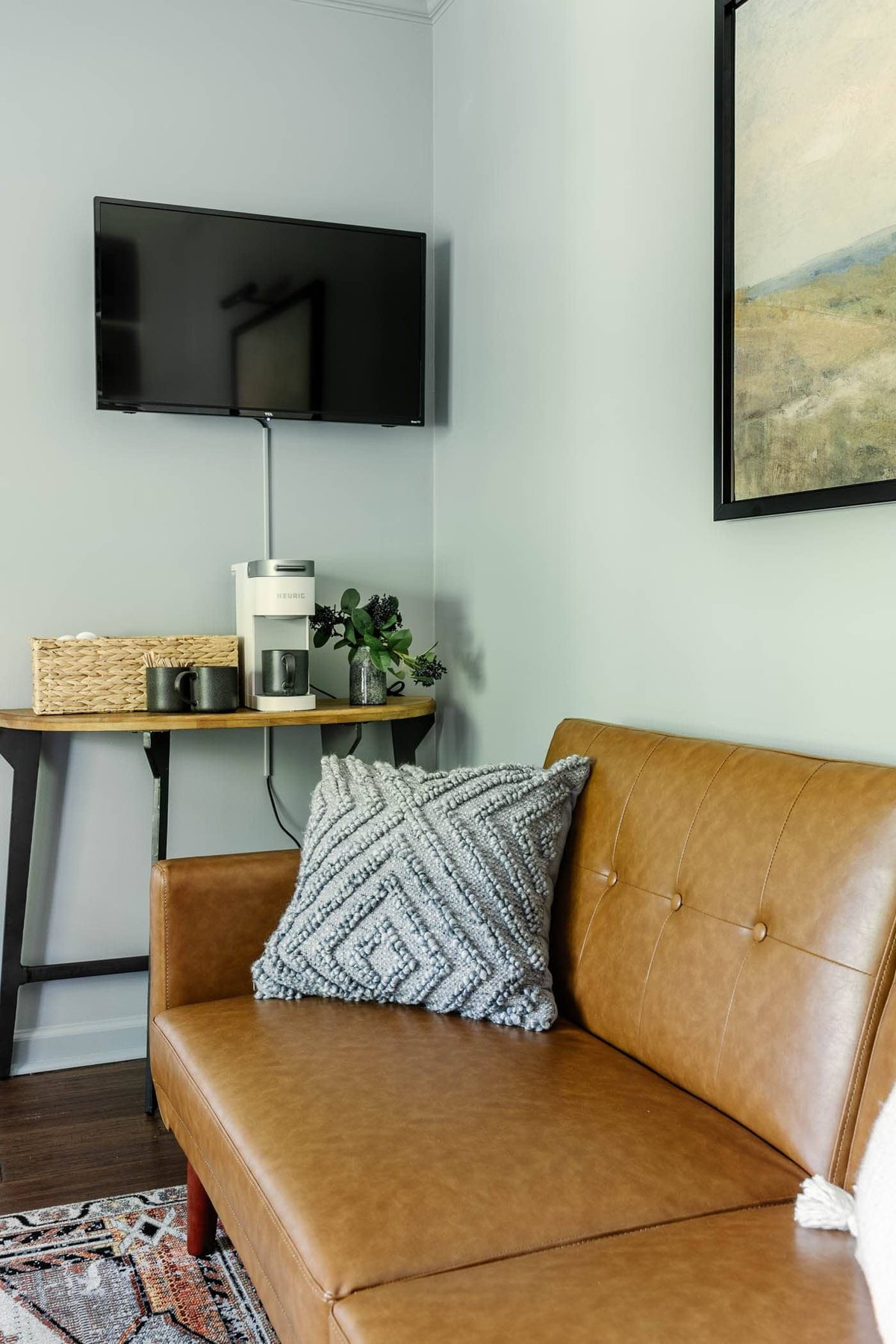 home office coffee bar table and wall mounted TV with a futon for guests