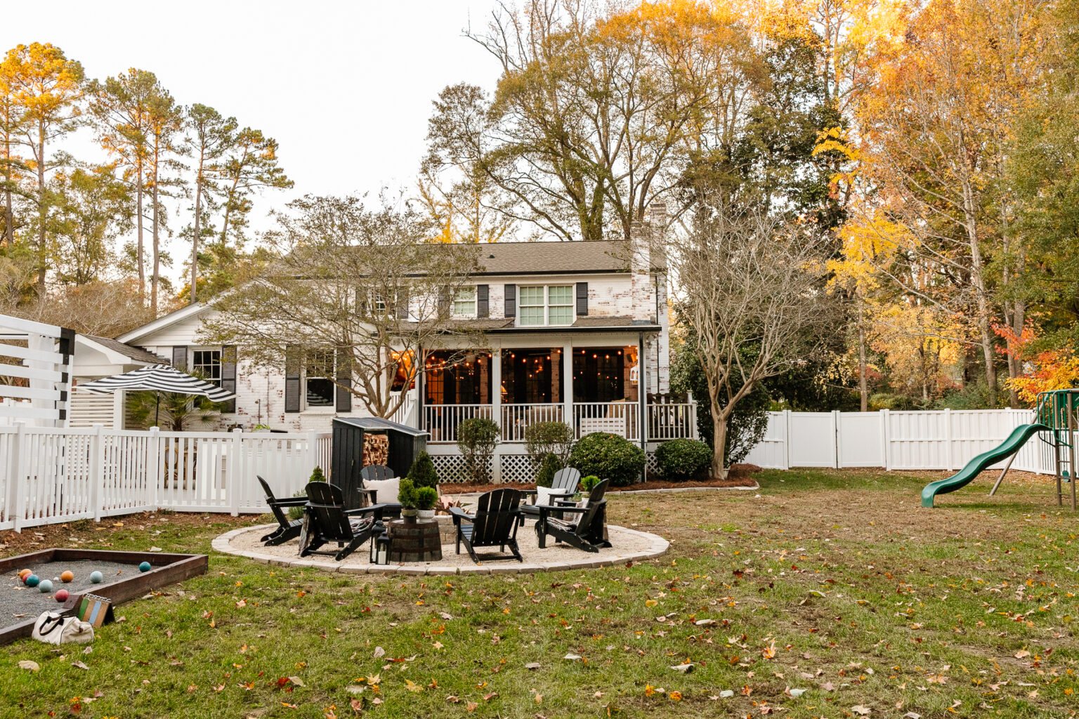 backyard remodel with fire pit, limewashed brick, playground, bocce ball court, and vinyl fence