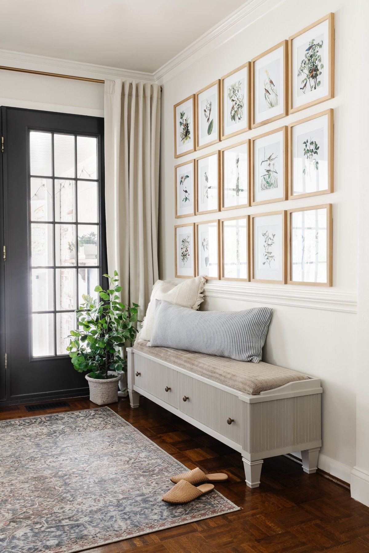 reeded bench in an entryway with an Audubon bird art gallery wall