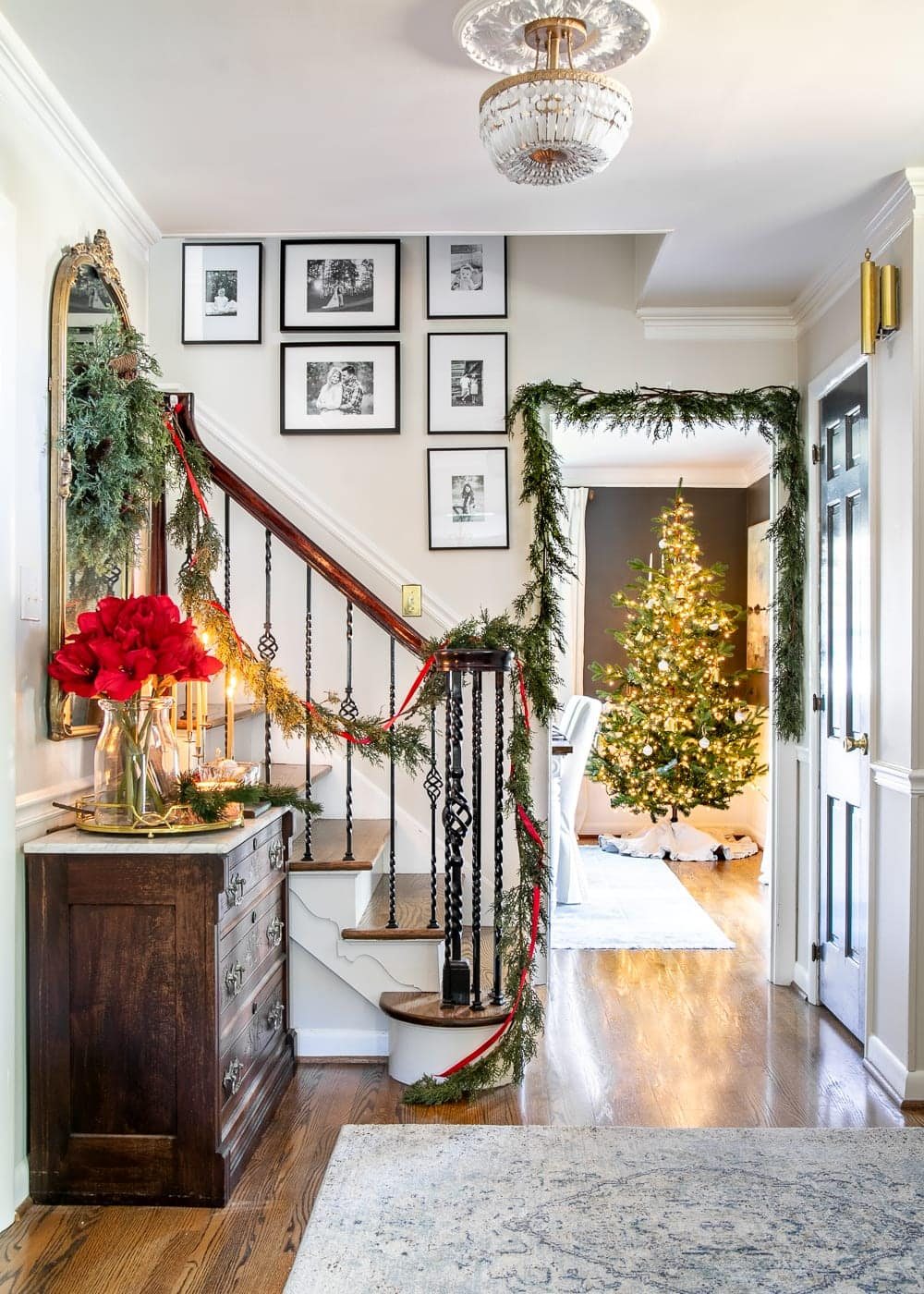 Christmas decor ideas | Modern meets traditional Christmas foyer with red amaryllis and real looking faux garland