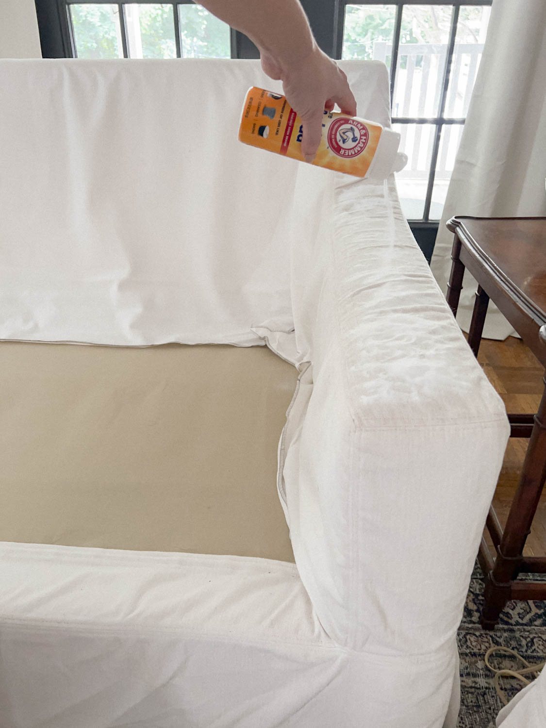 baking soda sprinkled on surface of couch to deodorize