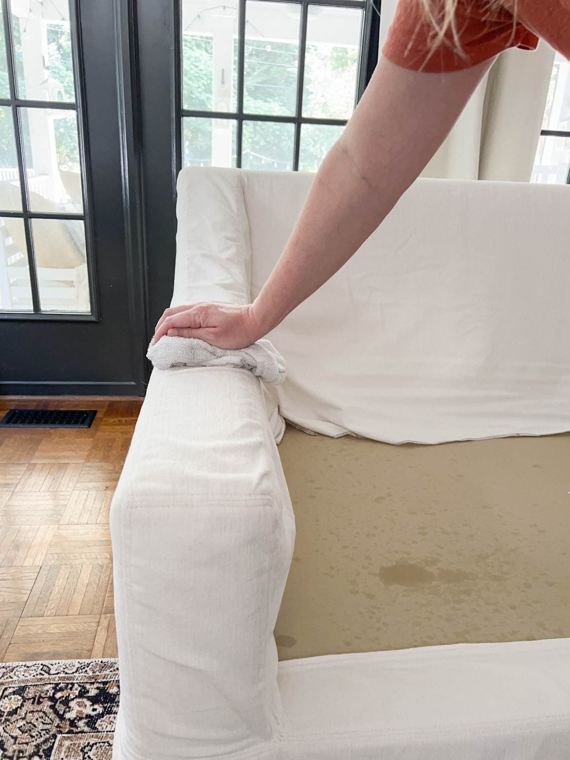 wiping up DIY couch cleaner on upholstery to clean a sofa