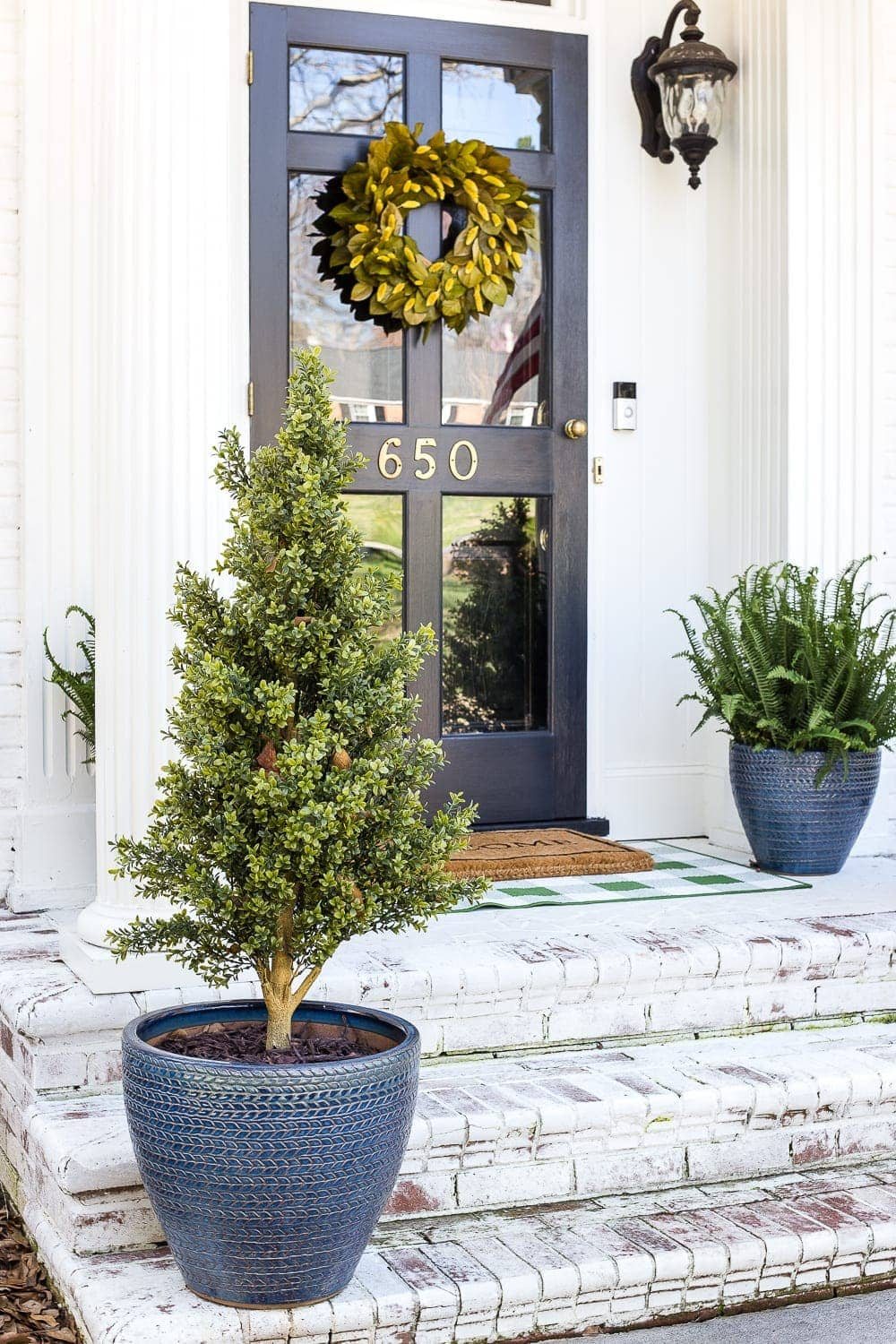 4 easy steps to decorate a small porch stoop for spring to make any home more welcoming for guests. #springporch #smallporch #porchstoop