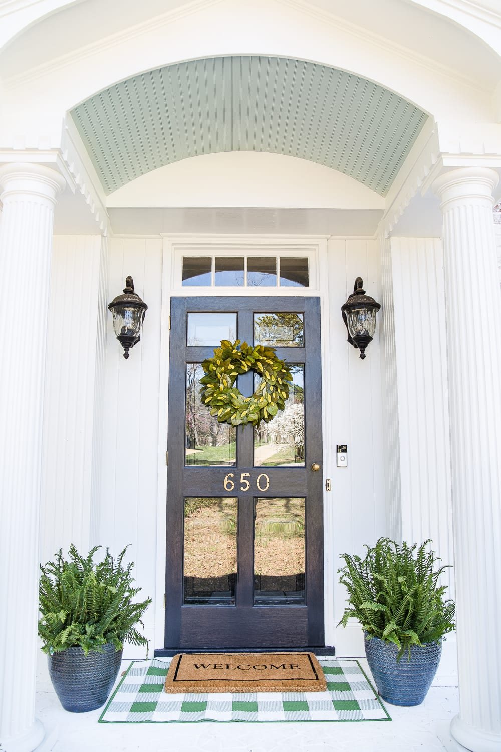 4 easy steps to decorate a small porch stoop for spring to make any home more welcoming for guests. #springporch #smallporch #porchstoop