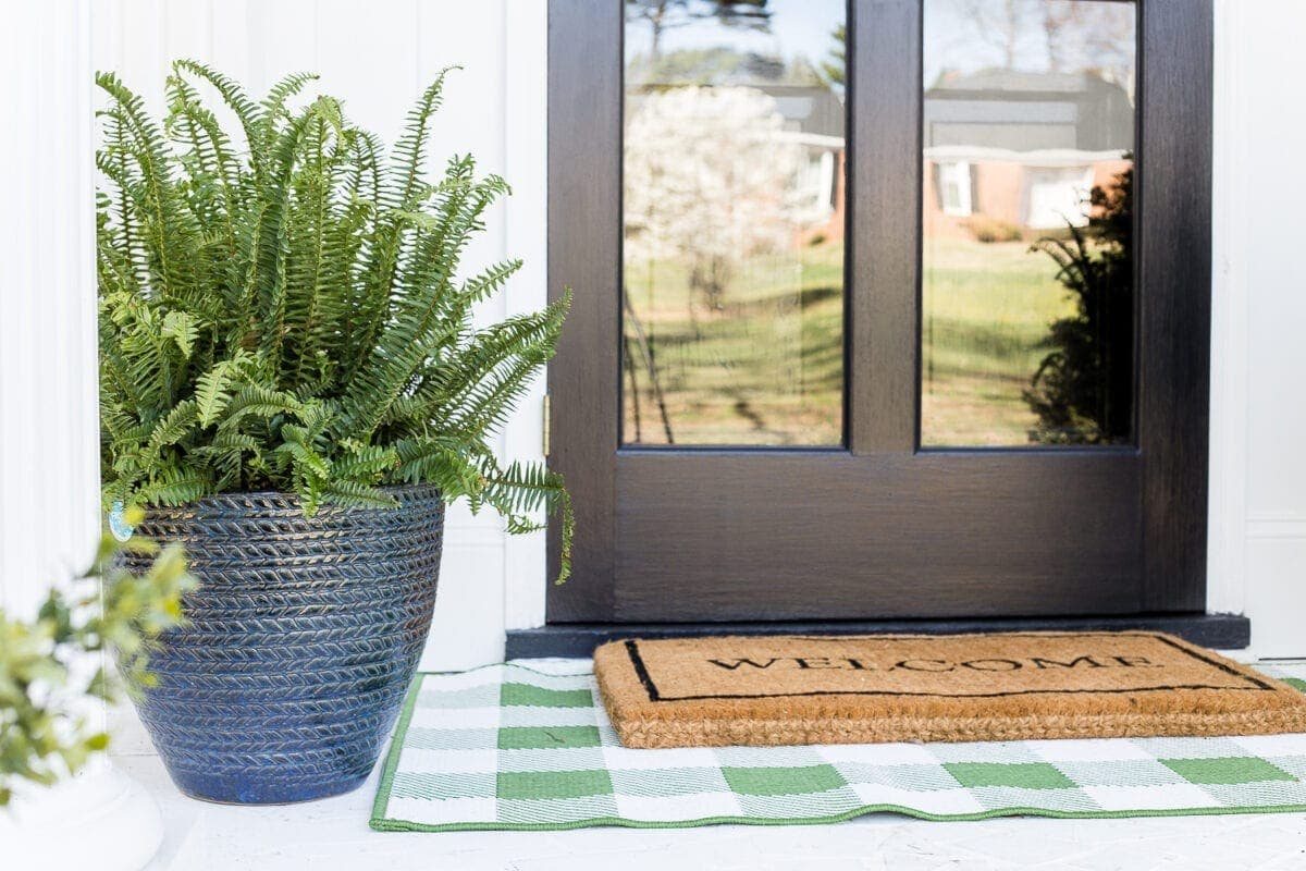 4 easy steps to decorate a small porch stoop for spring to make any home more welcoming for guests. #springporch #smallporch #porchstoop