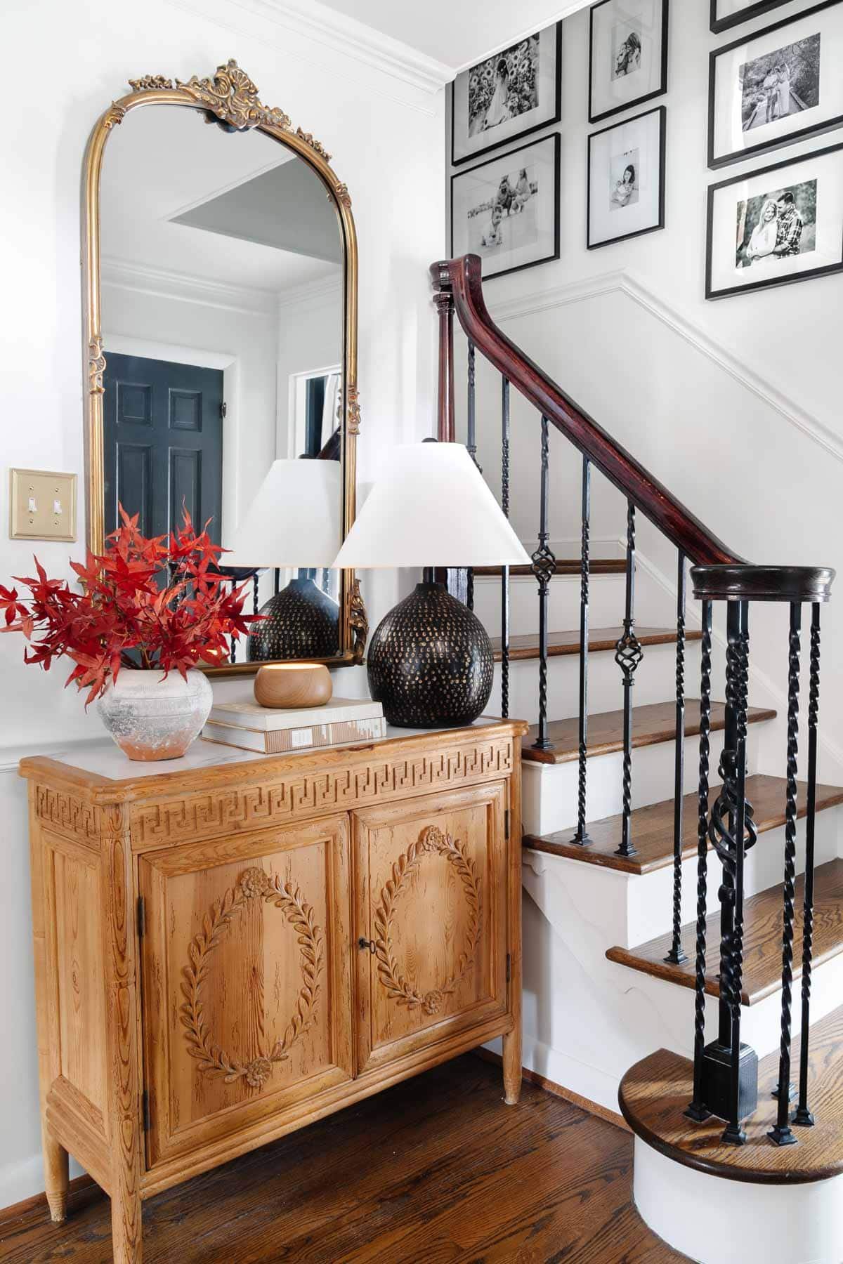 foyer table vignette with lamp, mirror, and fall leaves in vase