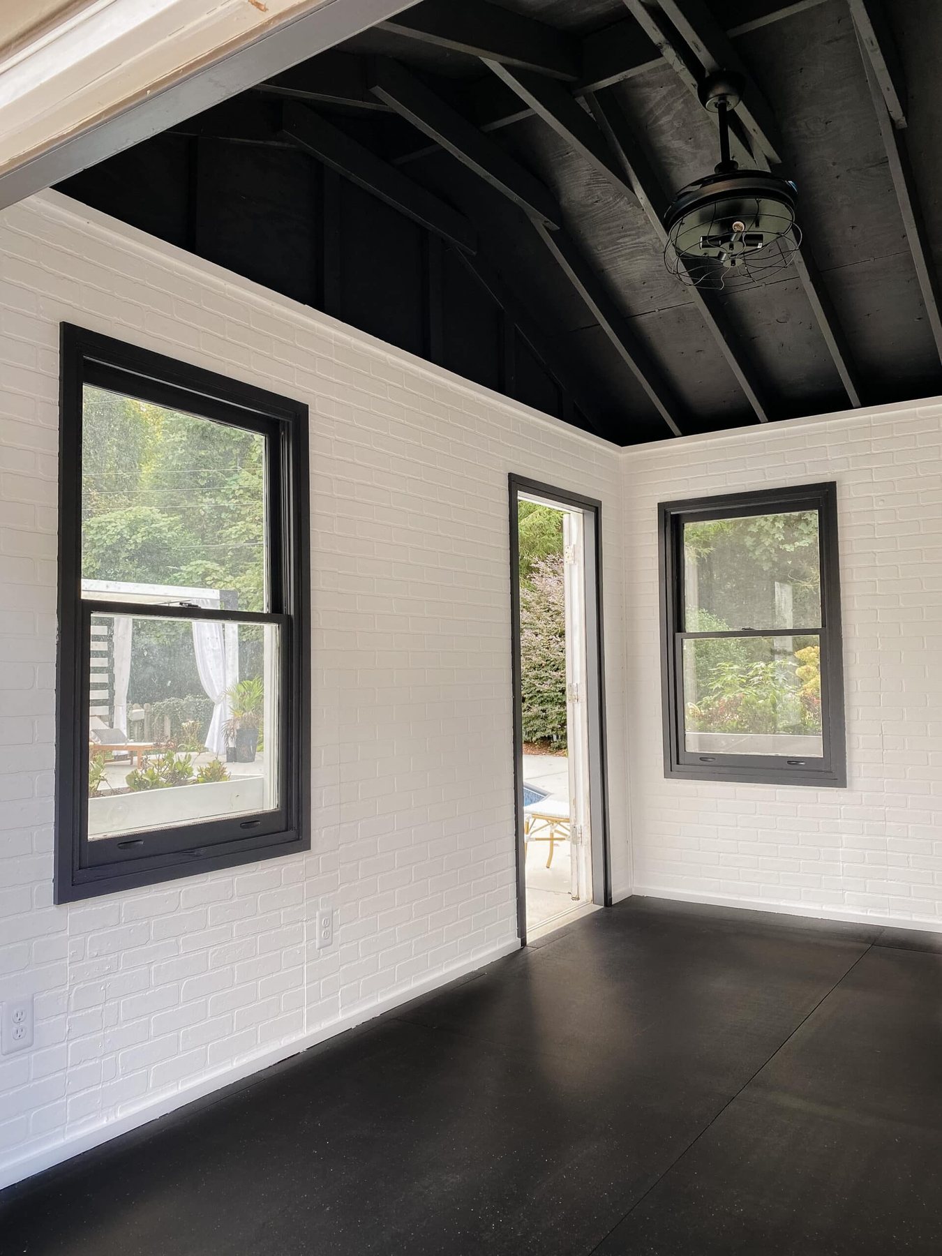 empty home gym shed with white brick and black ceiling