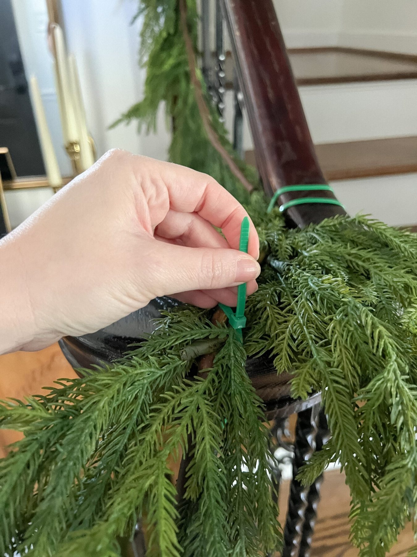 securing garland on stairs banister with zip ties