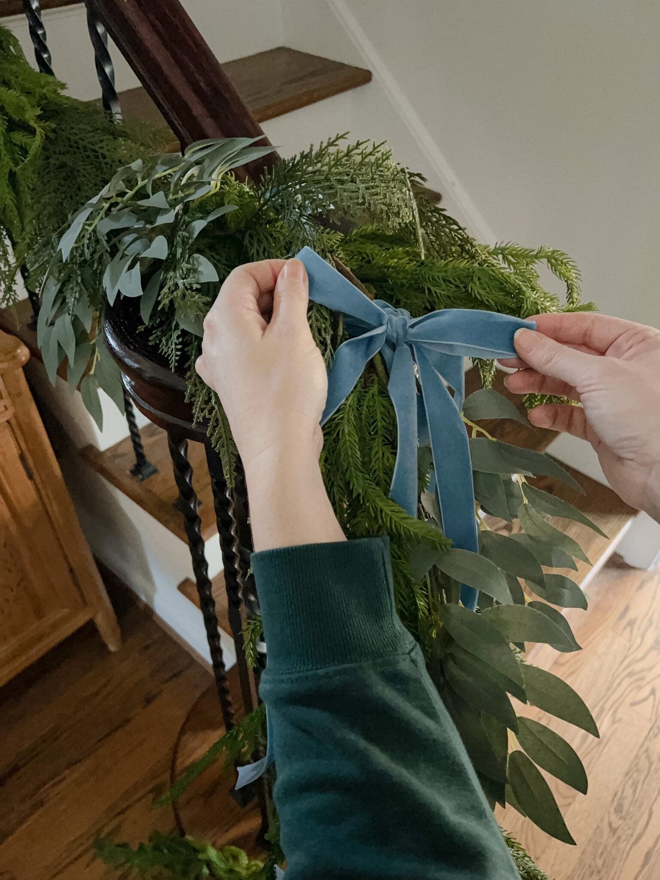 adding bows to staircase garland