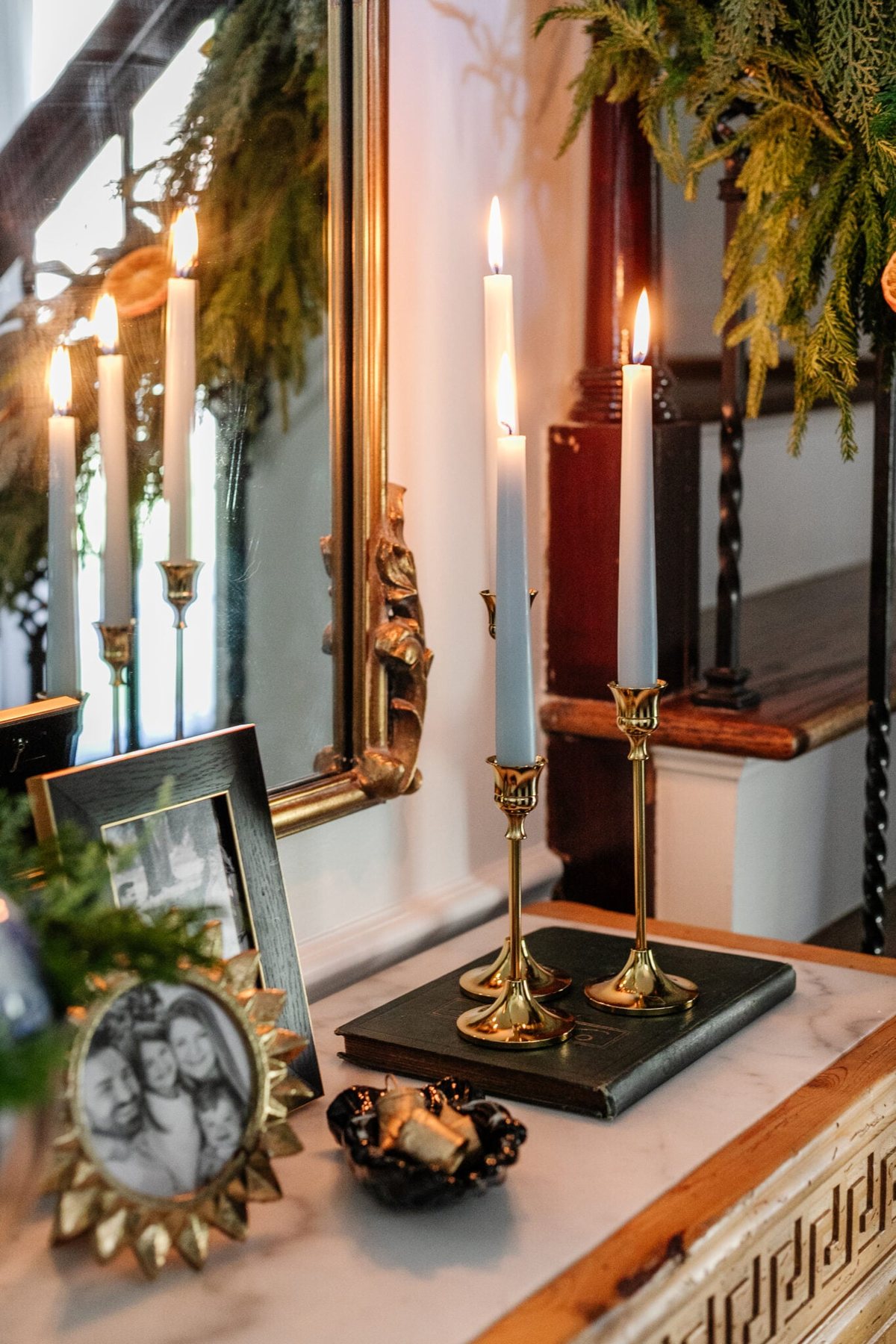 brass candlesticks with blue candles on an entryway table