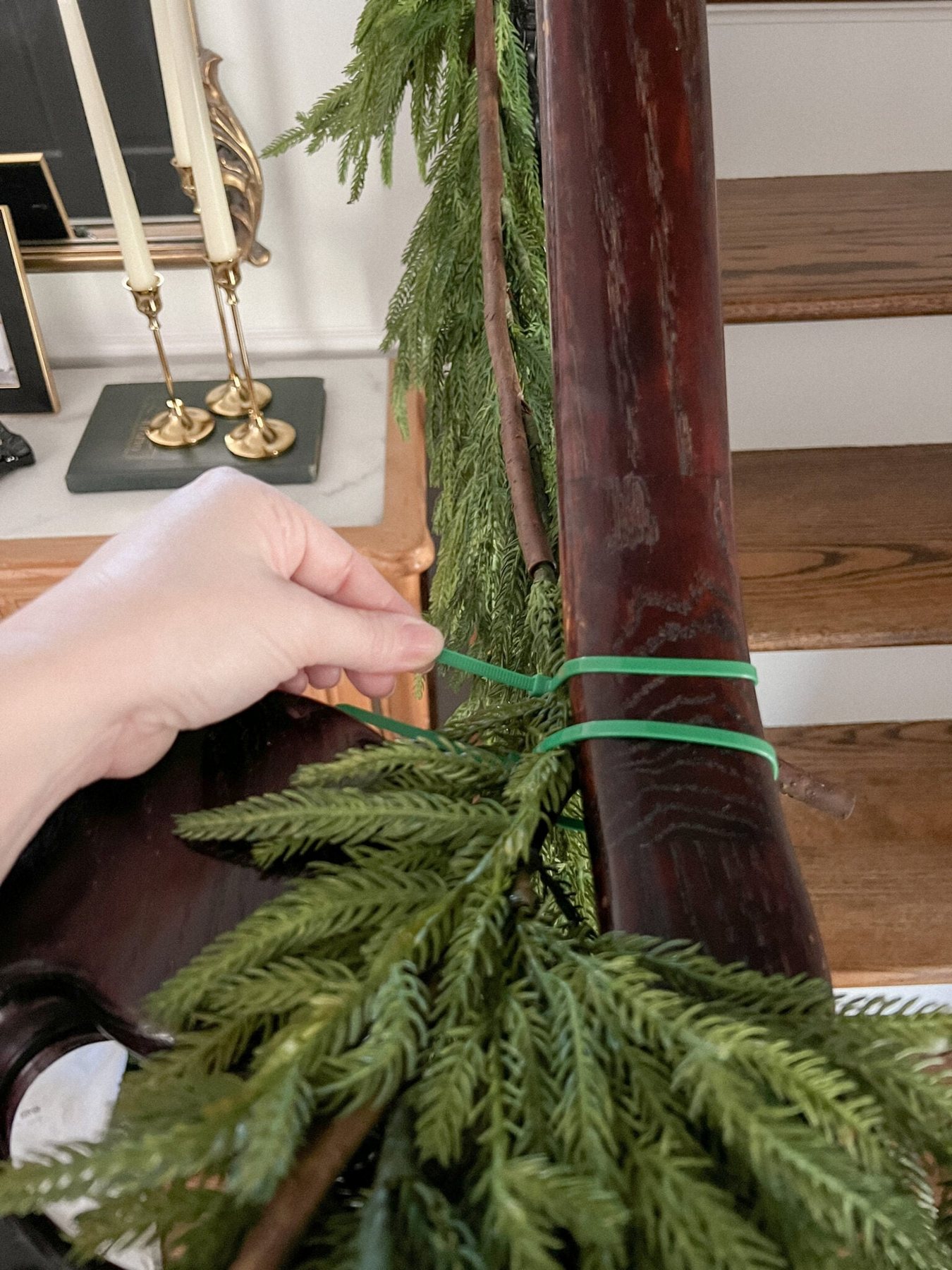 securing garland on stairs banister with zip ties