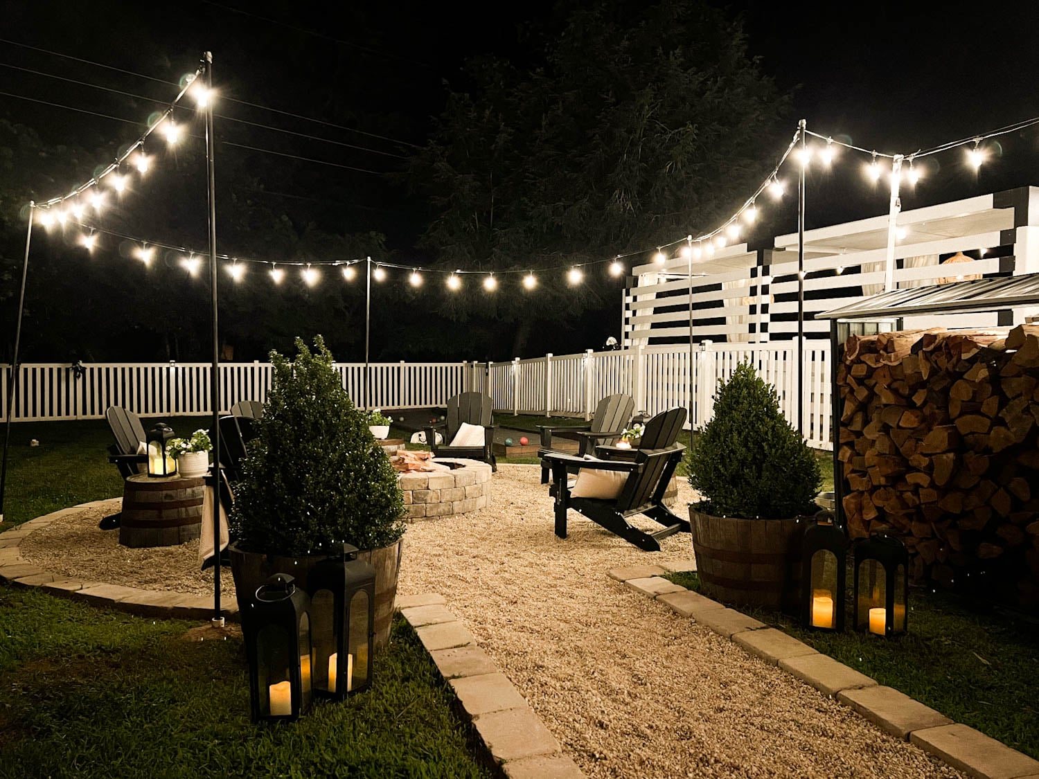 outdoor string lights around a fire pit in a backyard