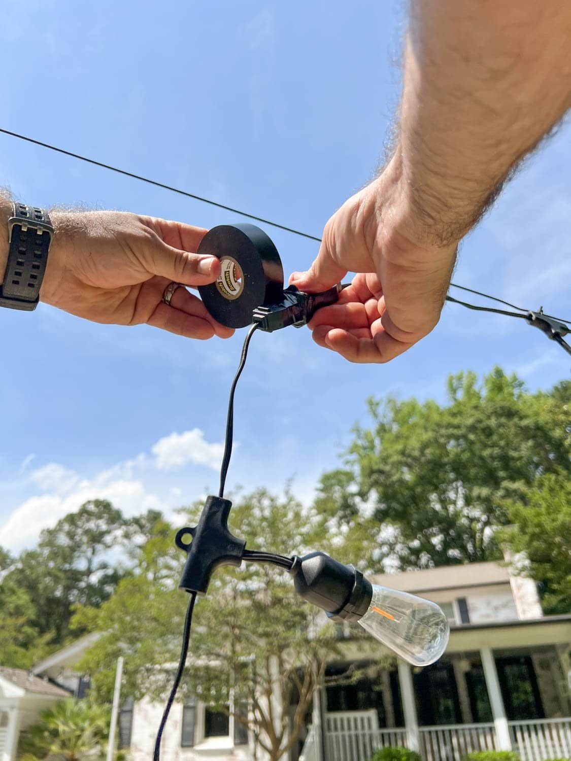 wrapping two string light strand plugs with black electrical tape
