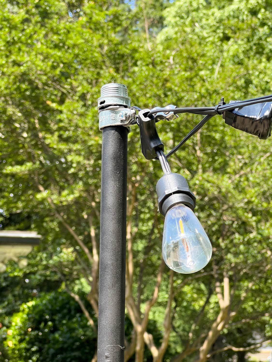 string lights attached to poles with squeeze connectors screwed to cable