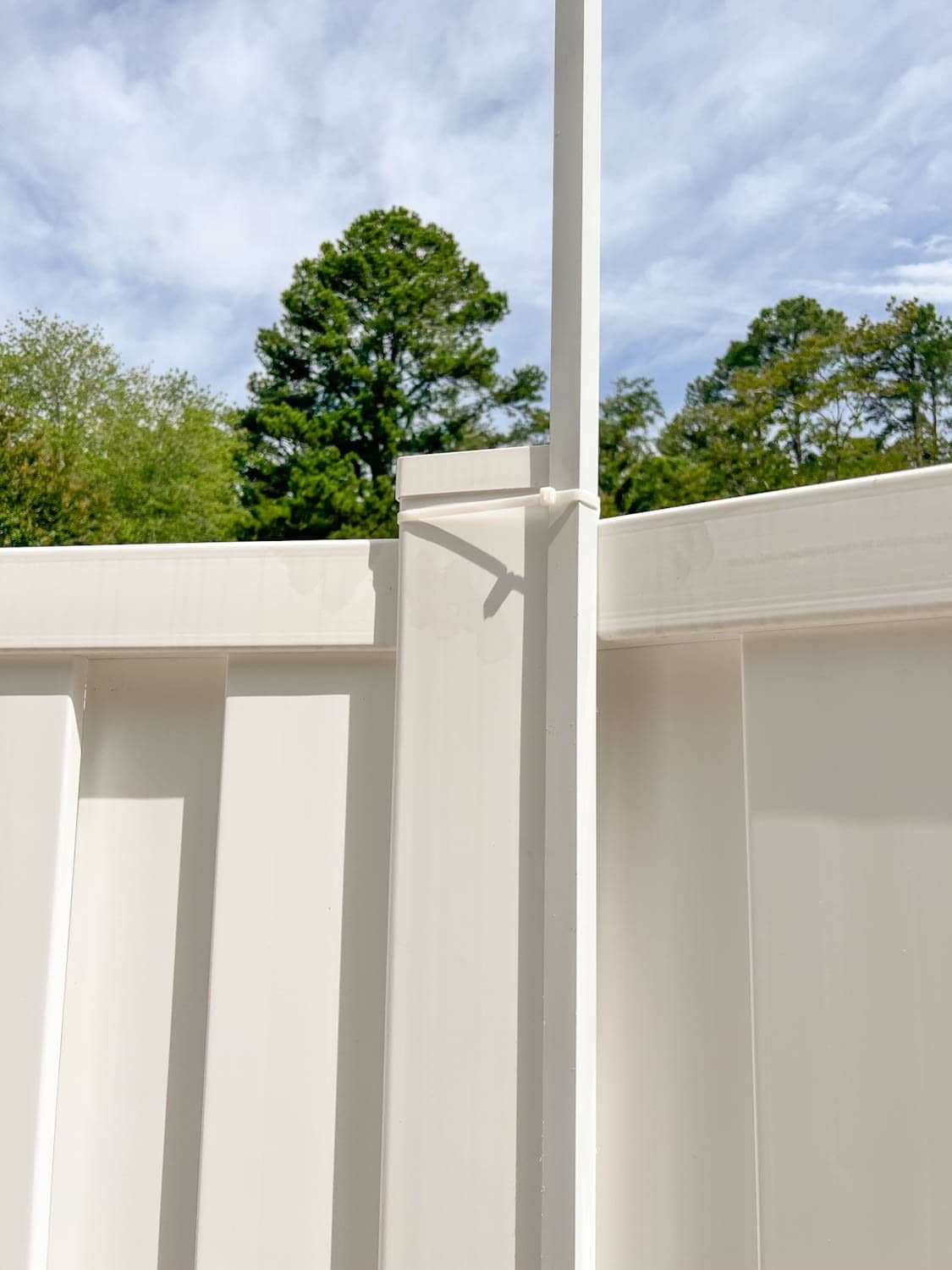 white square tubing attached with zip ties on a fence