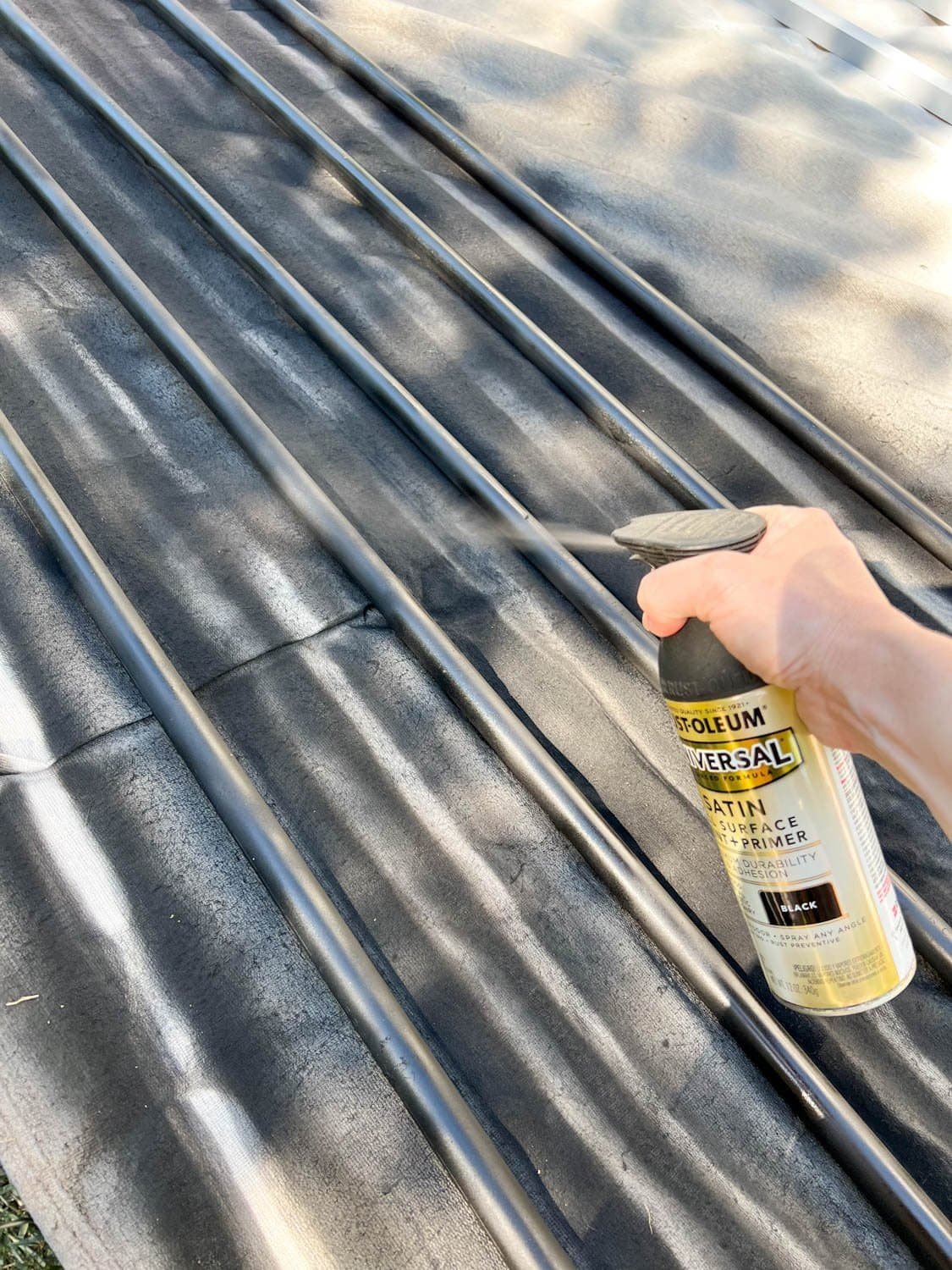 spray painting conduit black to make DIY string light poles