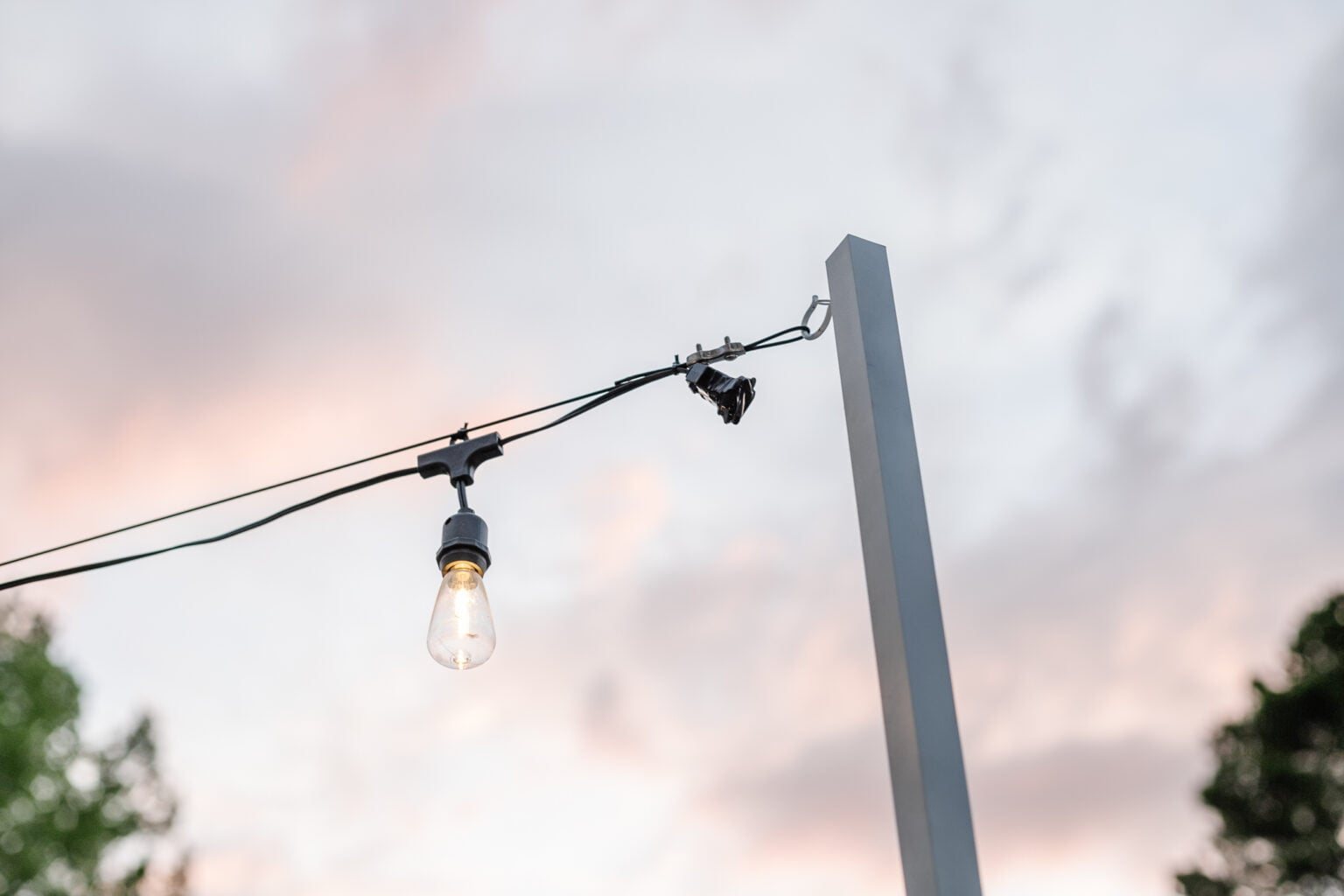 end of string light strand hanging from DIY string light pole