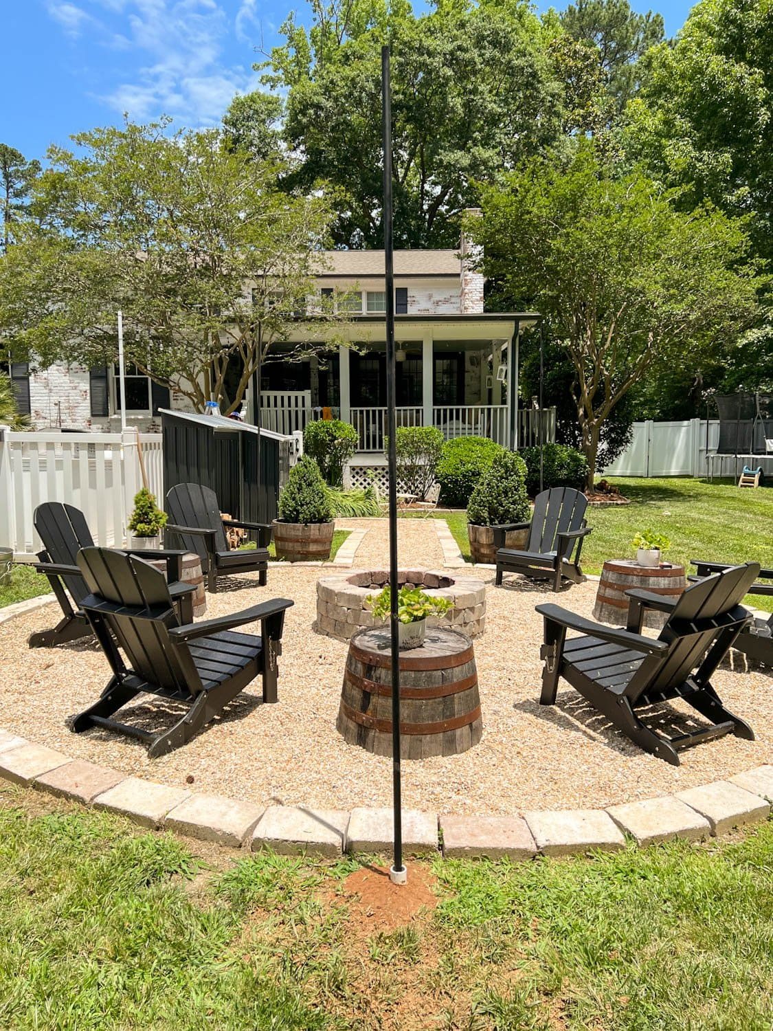 DIY string light poles around a fire pit made of conduit and PVC pipe