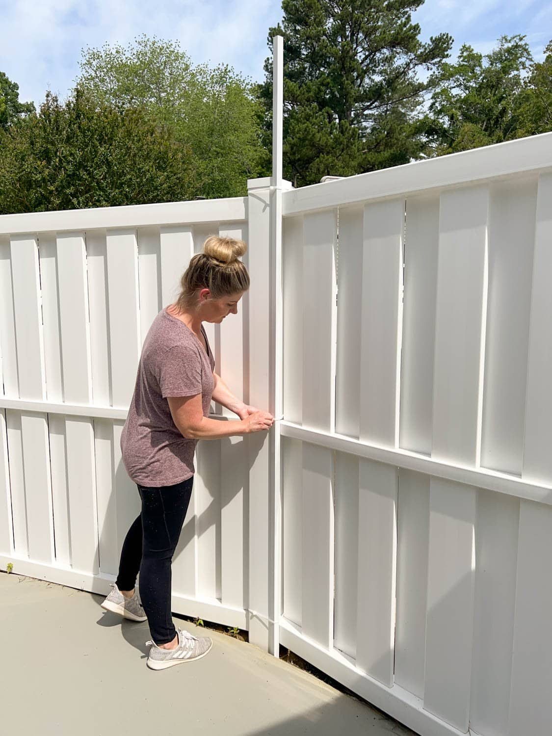placing white square tubing attached with zip ties to hang string lights on a fence