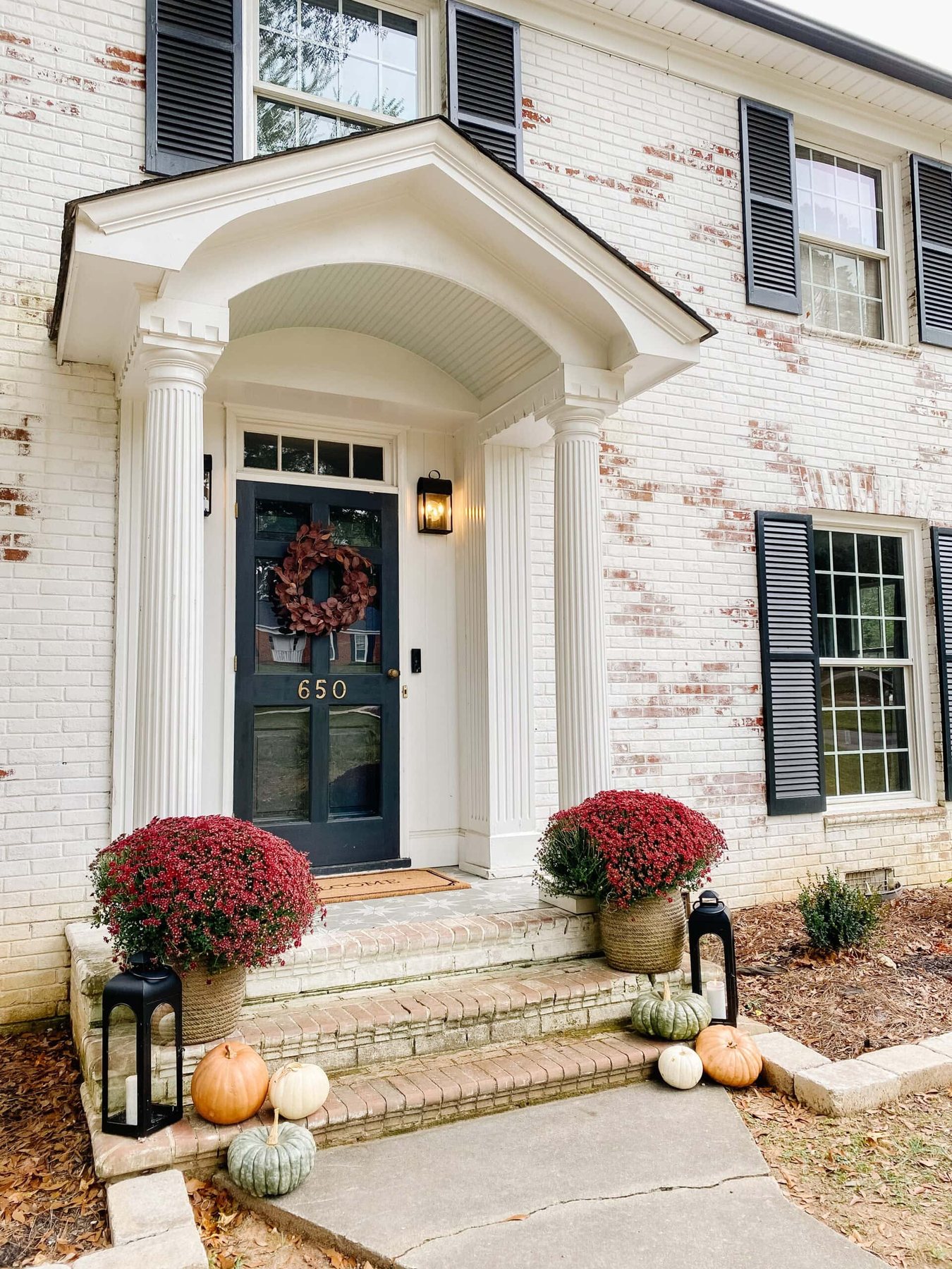 preserved pumpkins on a front porch decorated for fall