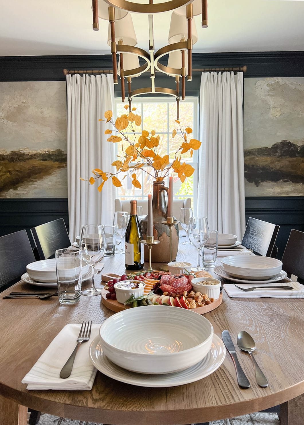 dinner table setting with fall centerpiece vase with fall branches and candles